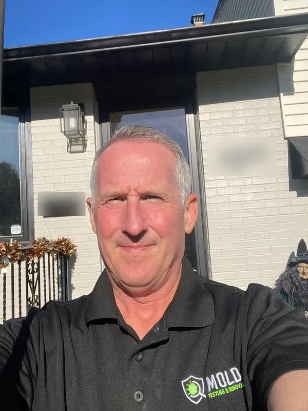 Mold Testing & Removal inspector Mike Richards in a branded uniform outside a Philadelphia home before a mold test